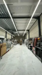 Yess! retail — distributiecentrum met lineaire LED-verlichting en industriële binnenafwerking door Fresh Decor Limburg