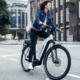 Vrouw fietst op een witte Riese & Muller door de stad