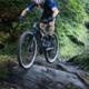 Mountainbike in de bergen en over de rotsen, in blauw shirt