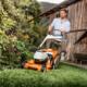 Oranje grasmaaier in robuuste tuin